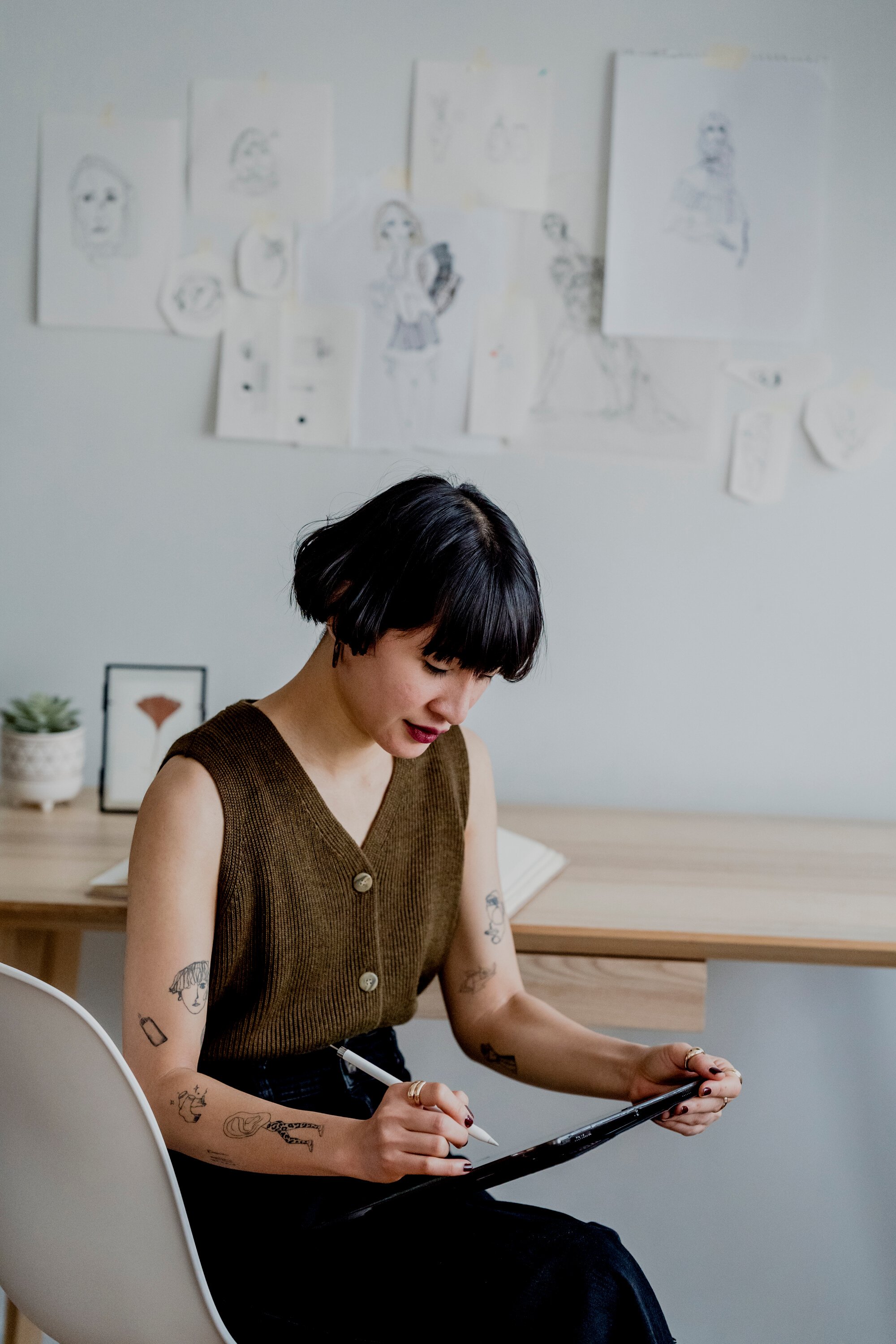 Serious lady making sketches on graphic tablet